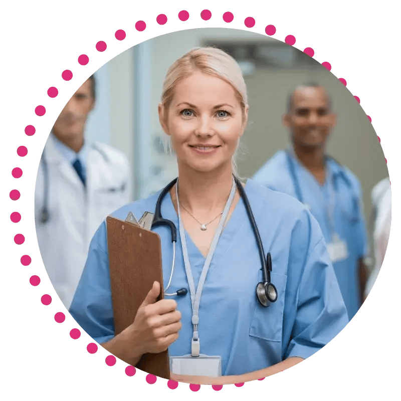 A female healthcare professional in scrubs holding a clipboard and wearing a stethoscope.