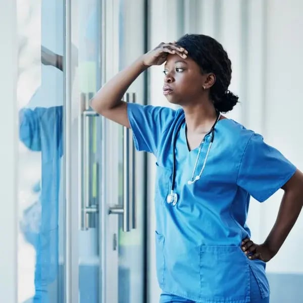 A blue uniform doctor with the hand in her forehead with a worrying look