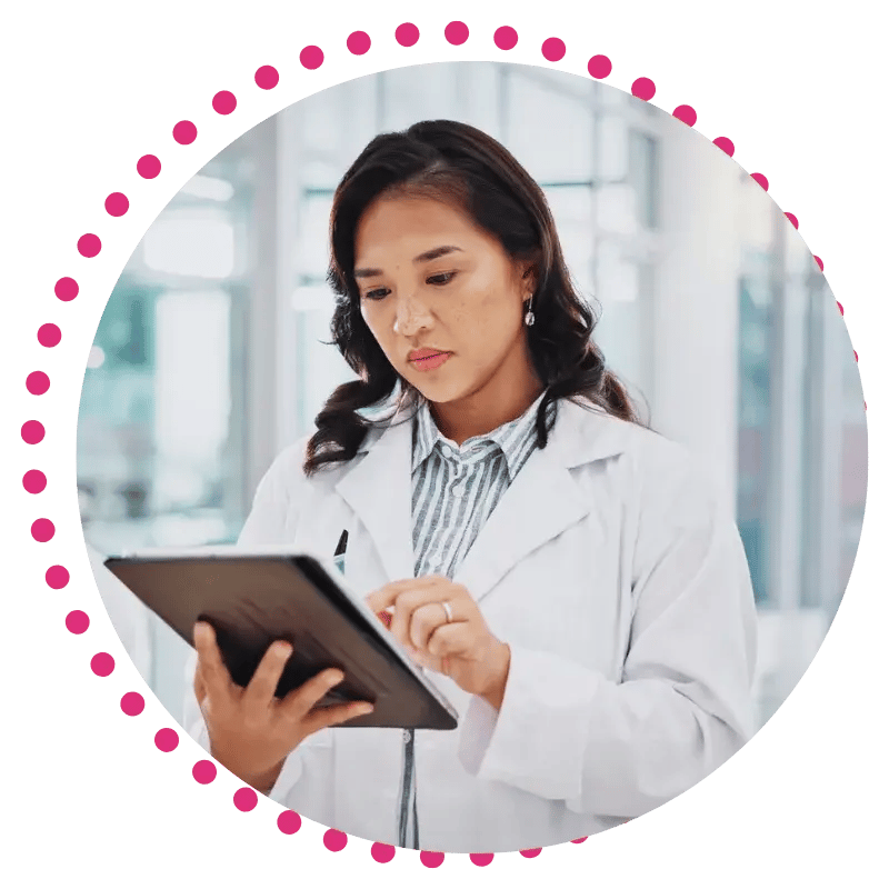A female healthcare professional in a white coat holds a tablet, looking engaged and ready to assist patients with digital information.
