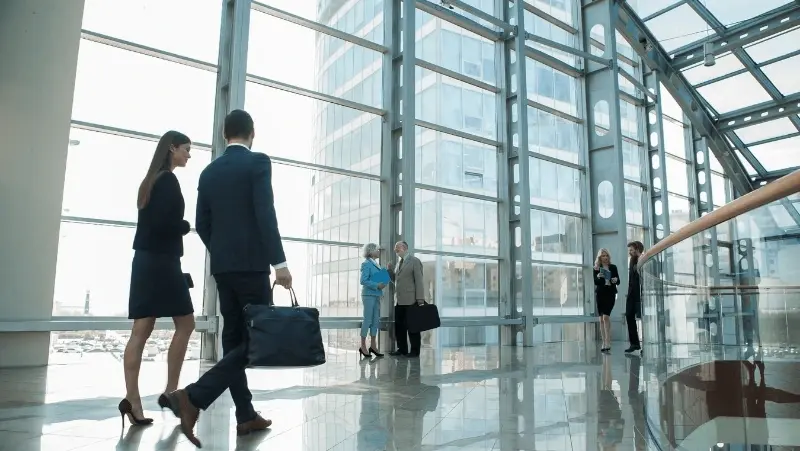 Business people walking and talking in a glass building