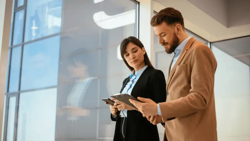 A man and a woman looking at a report in the man's hands