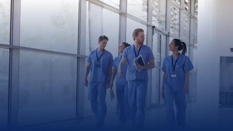 A group of doctors walking in a hospital aisle
