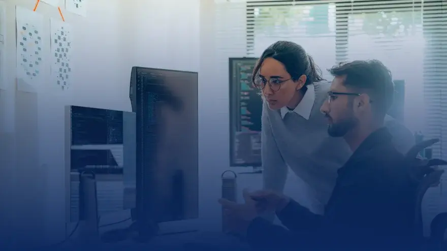 Two colleagues checking a code on a screen